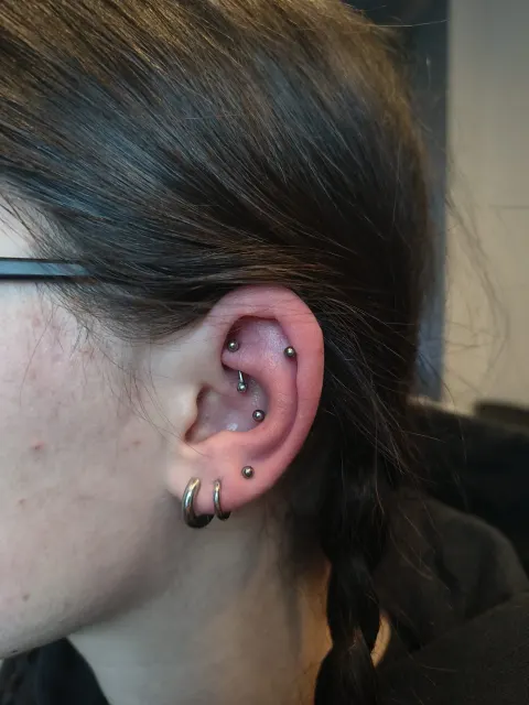Kompozycja kilku rodzajów piercingu ucha z dopasowaną biżuterią. W One More Tattoo wykonujemy różne przekłucia uszu i pomagamy dobrać ich rozmieszczenie oraz odpowiednią biżuterię.